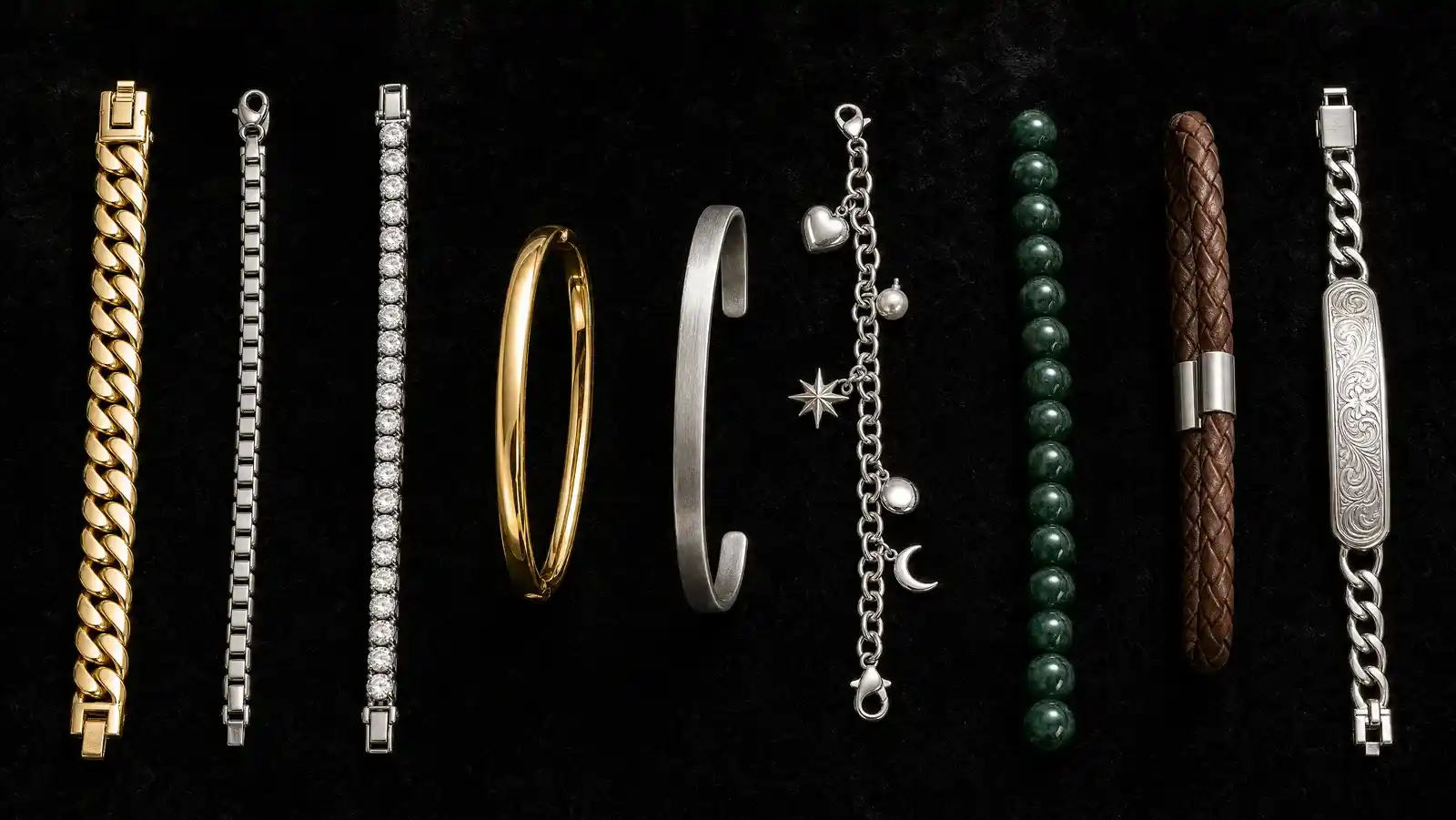 Nine bracelet styles laid side by side on black velvet including gold curb link, silver box chain, diamond tennis, bangle, cuff, charm, beaded, leather and ID bracelets